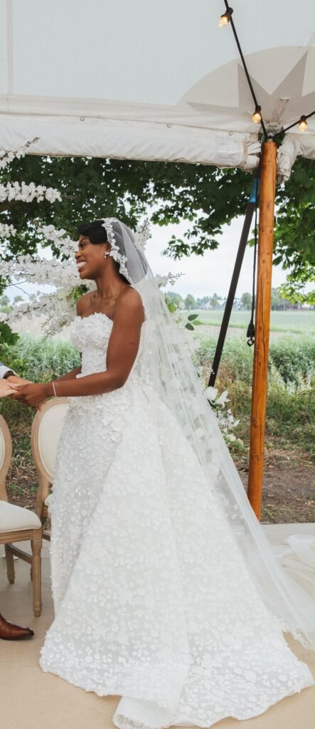 Bride in a lace ballgown at an outdoor ceremony