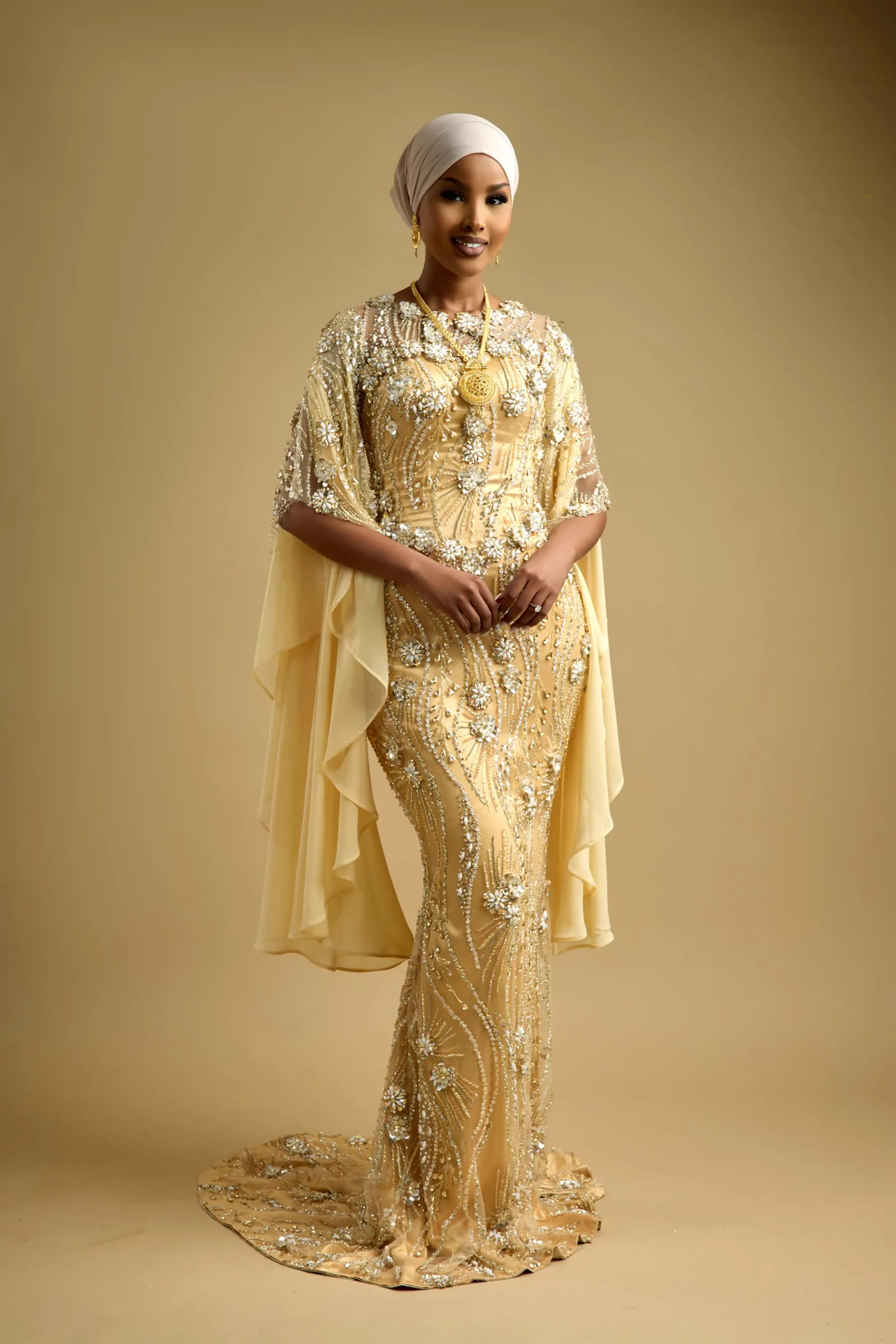 ANSSA gown in gold beadwork with a draped chiffon cape