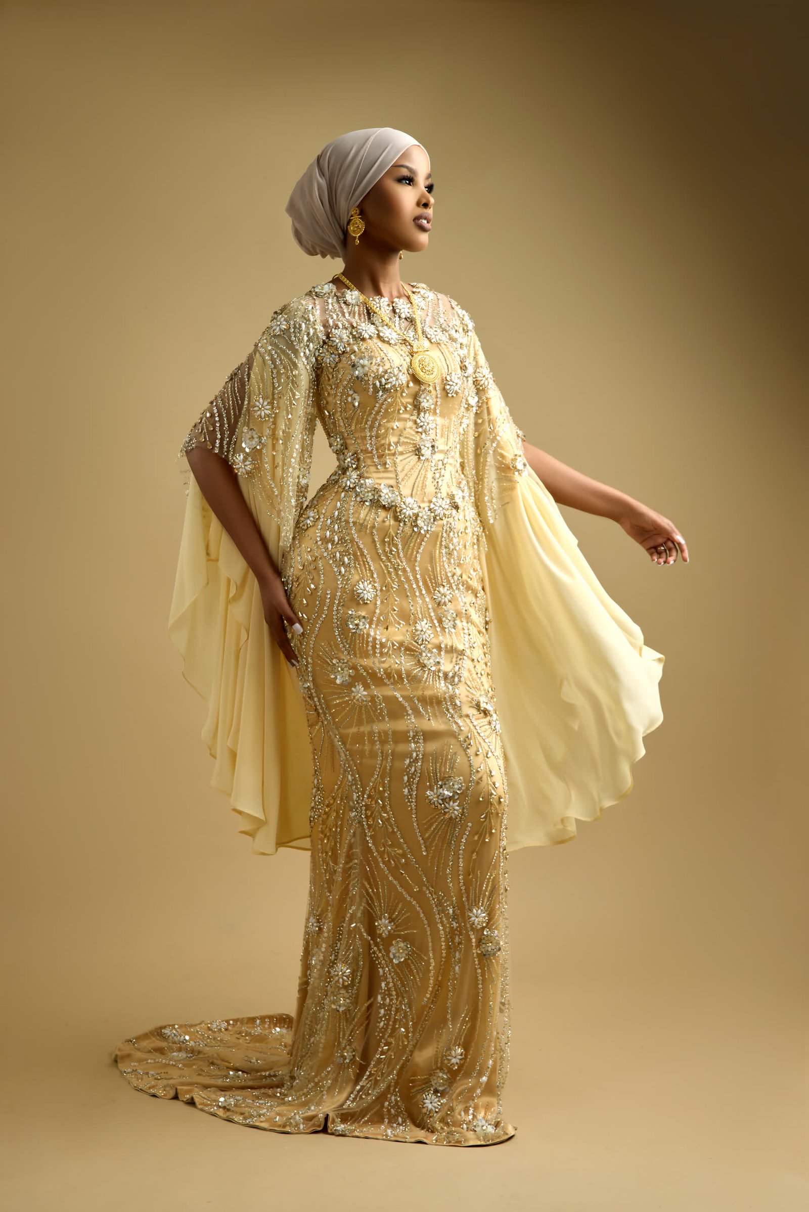 Hand-beaded gold gown with chiffon cape sleeves opened out from the shoulder
